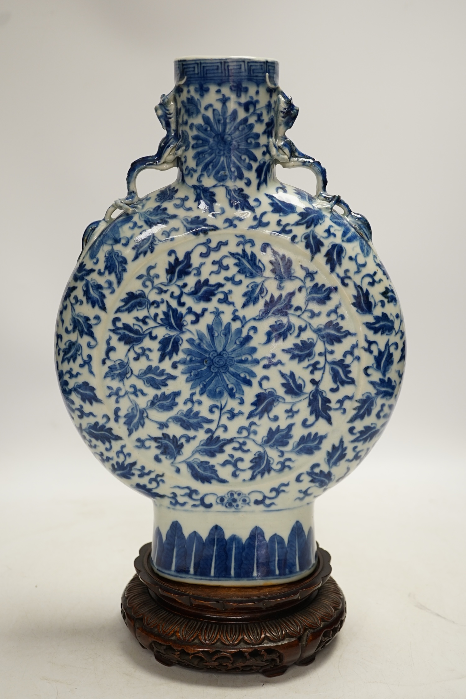 A 19th century Chinese blue and white moon flask on a hardwood stand, overall 35cm high. Condition - typical minor glaze imperfections